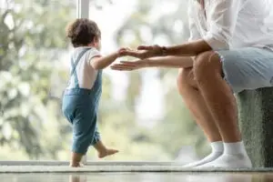 Kinderwillkommensfest Ein Kind läuft an der Hand gestützt